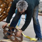 Sculptor Vaughn Randall assembles individual castings into the spherical sculpture, spanning 8 feet in diameter, at Downtown Commons.