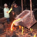 Clarksville Foundry employees pour molten iron into a series of molds.